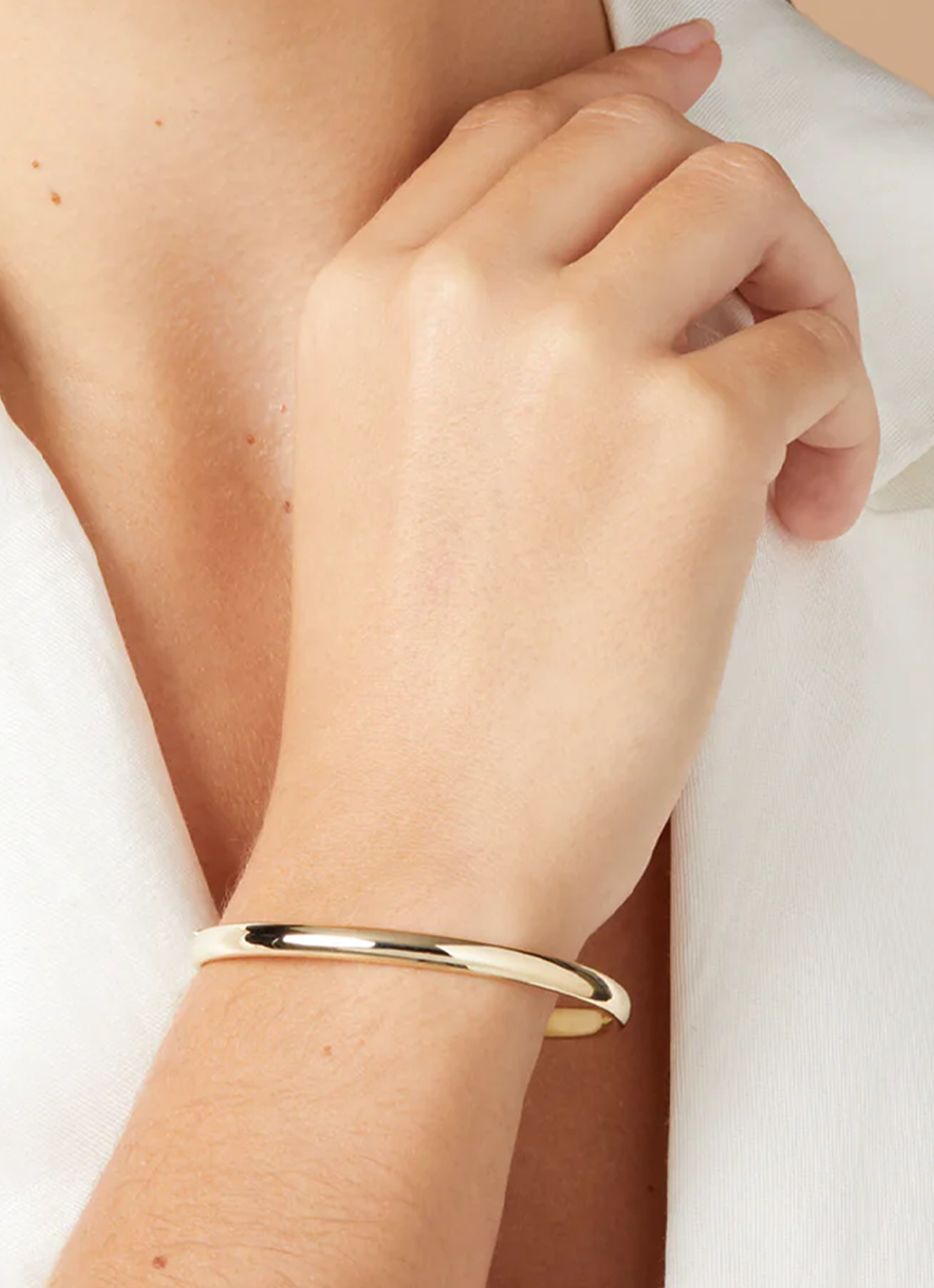 Guldfärgat armband med rund form och blank yta