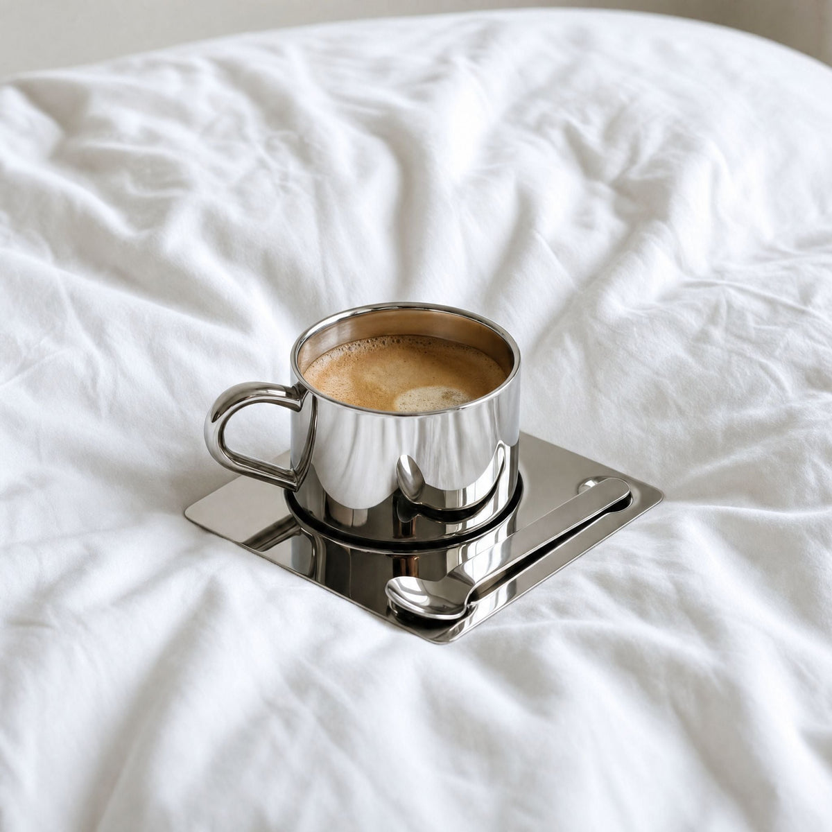 Kaffekopp med fat och sked i spegelblank silverfinish