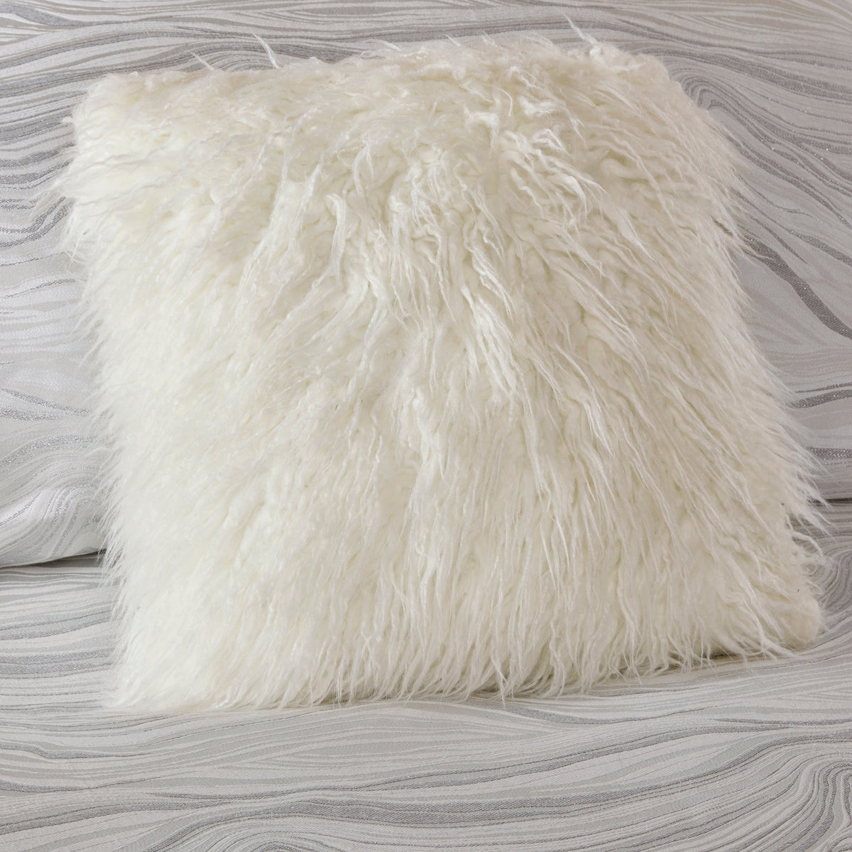 Vitt jacquardöverkast med vågmönster och matchande dekorativa kuddar