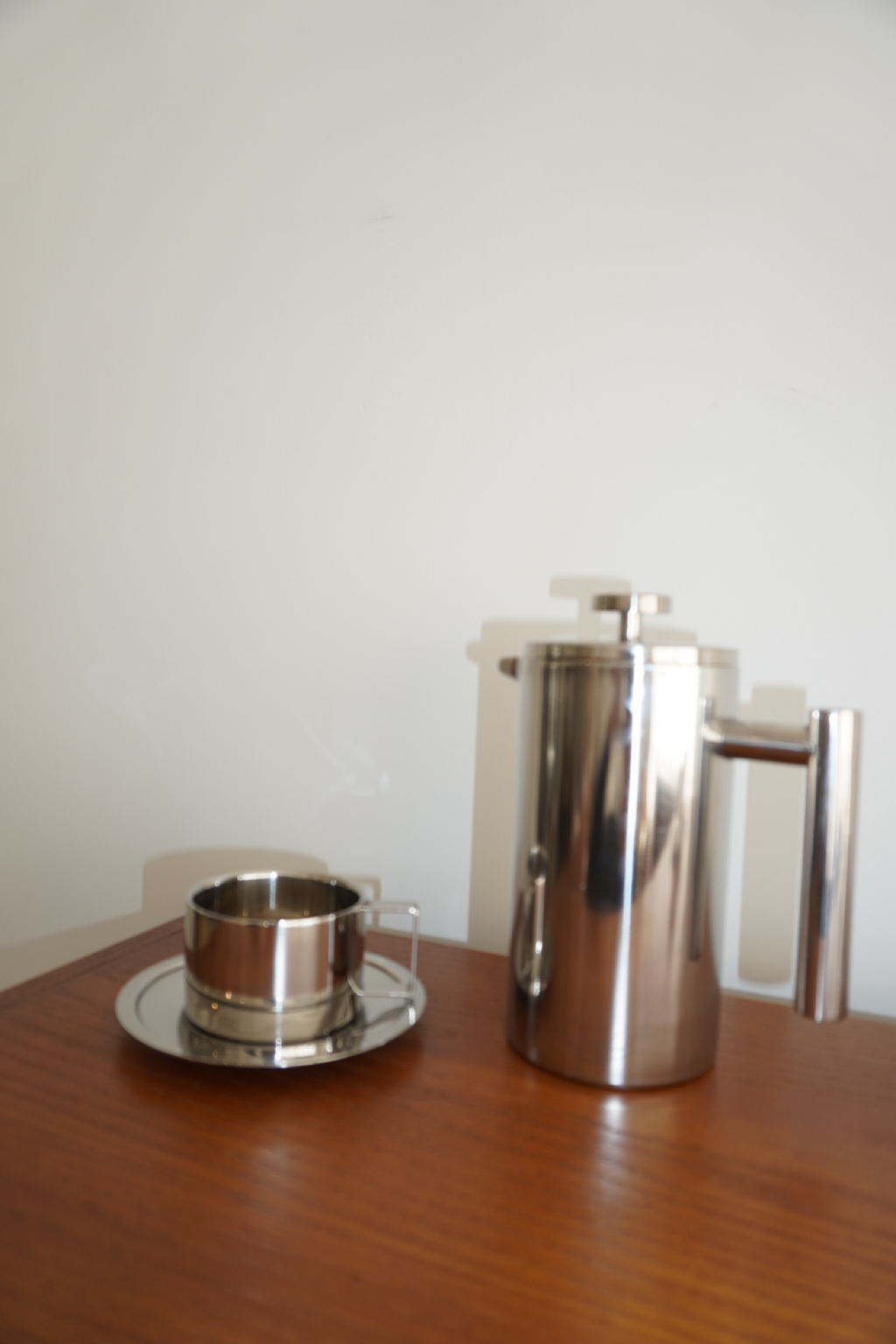 Kopp med fyrkantigt handtag och matchande fat i blank silverfinish