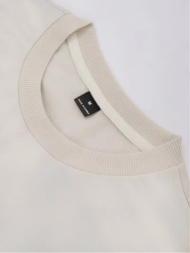 Beige oversized långärmad tröja med stor mörk textdesign på rygg och ärmar