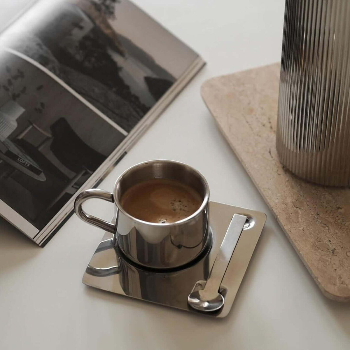 Kaffekopp med fat och sked i spegelblank silverfinish