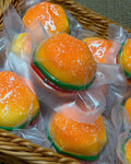 Orange hamburgerformad mjuk klämboll med gröna och röda detaljer