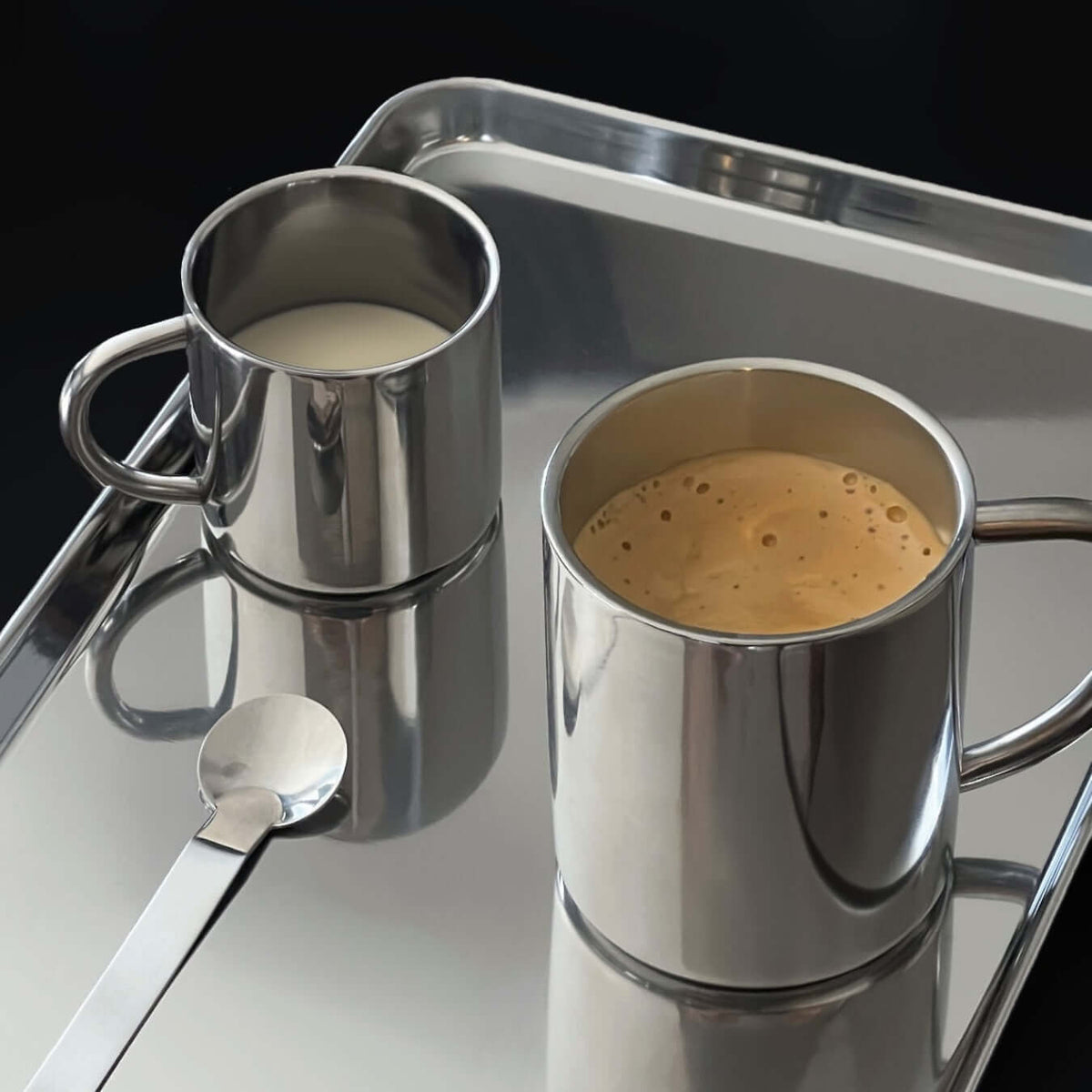 Blank silverfärgad kopp i rostfritt stål med dubbla väggar och handtag