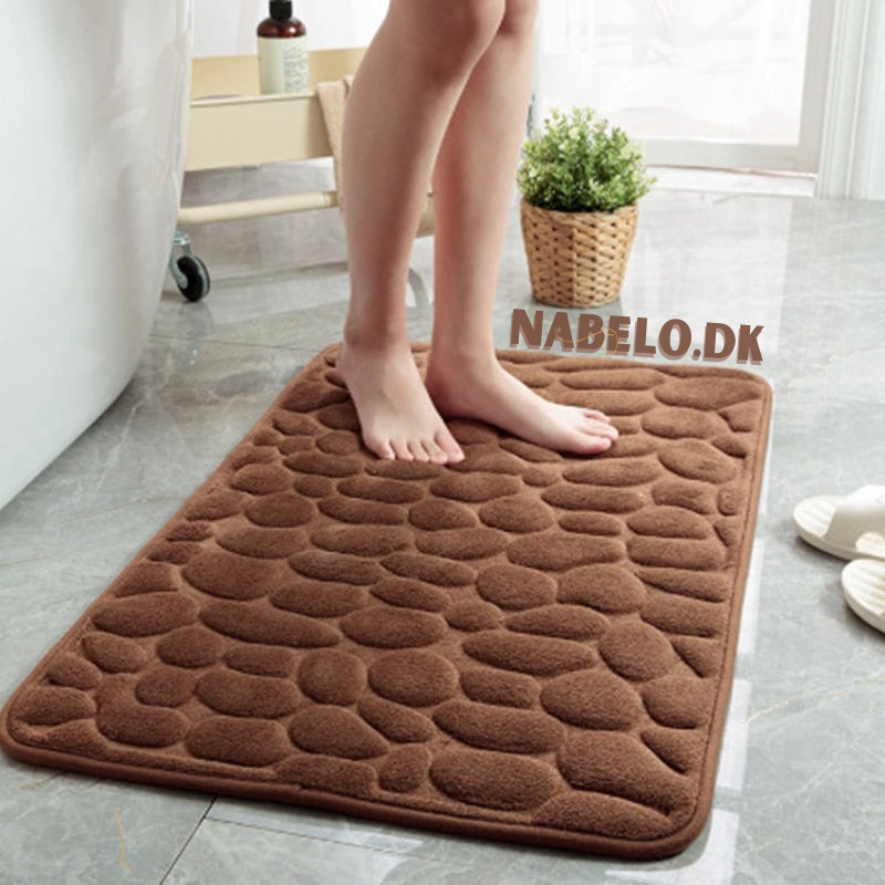 Rektangulär badrumsmatta med upphöjt stenmotiv och mjuk yta