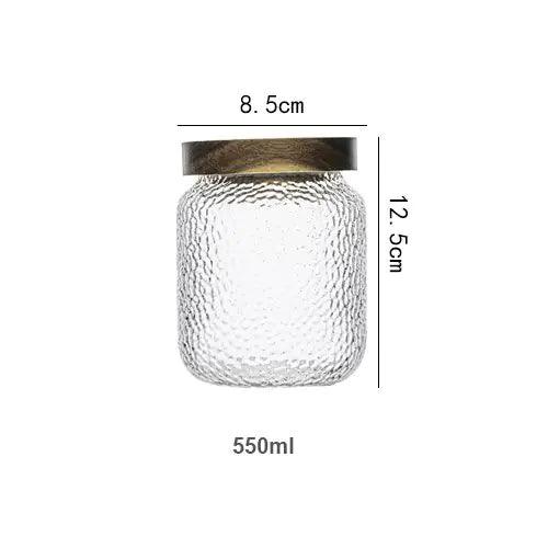 Transparent förvaringsburk i hamrat glas med mörkt trälock