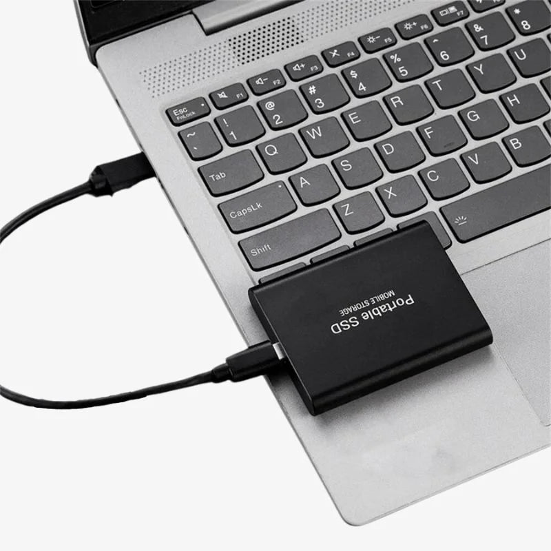 Portabel extern SSD-enhet med kabel ansluten till en laptop