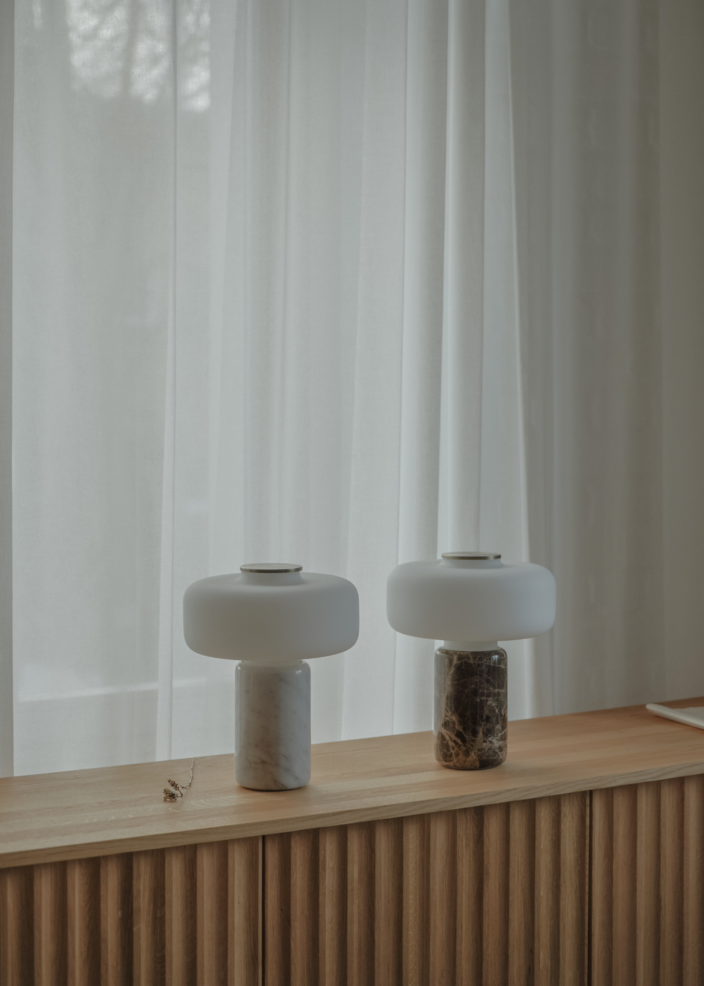Vit bordslampa med rundad skärm, marmorerad fot och guldfärgad detalj