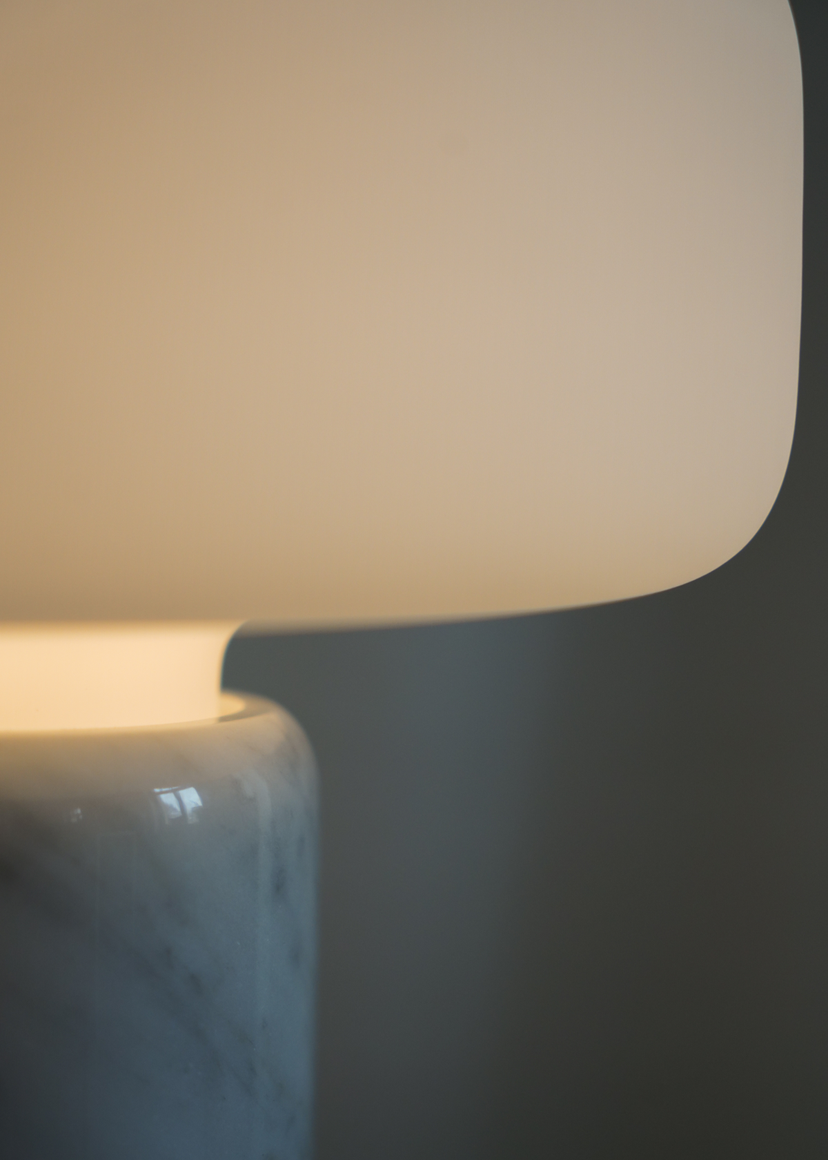 Vit bordslampa med rundad skärm, marmorerad fot och guldfärgad detalj