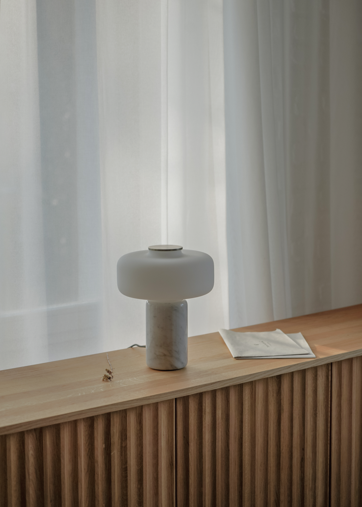 Vit bordslampa med rundad skärm, marmorerad fot och guldfärgad detalj