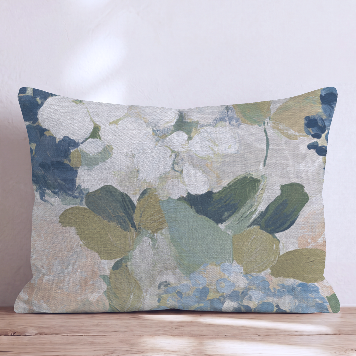 Beige prydnadskudde med blått och grönt blommönster i en soffa