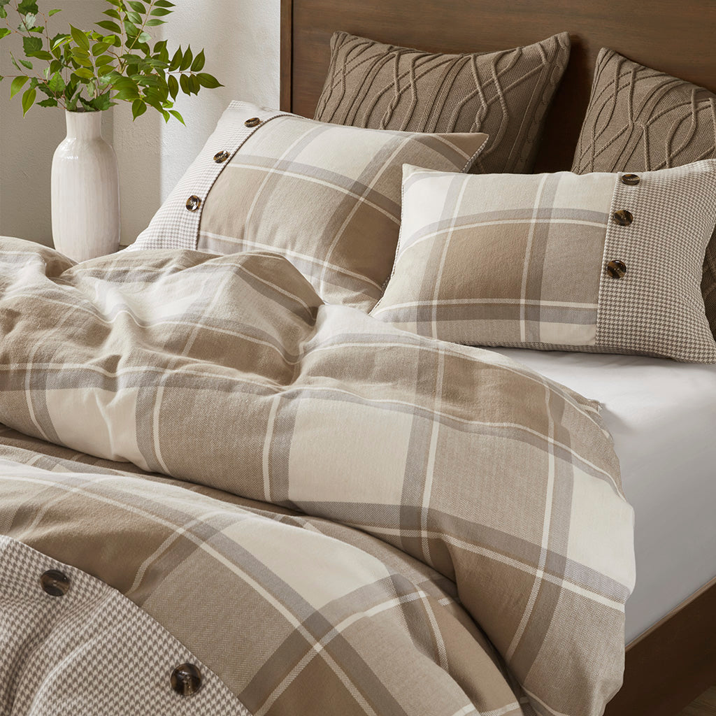 Rutigt påslakanset med matchande örngott och dekorativa knappar på en bäddad säng
