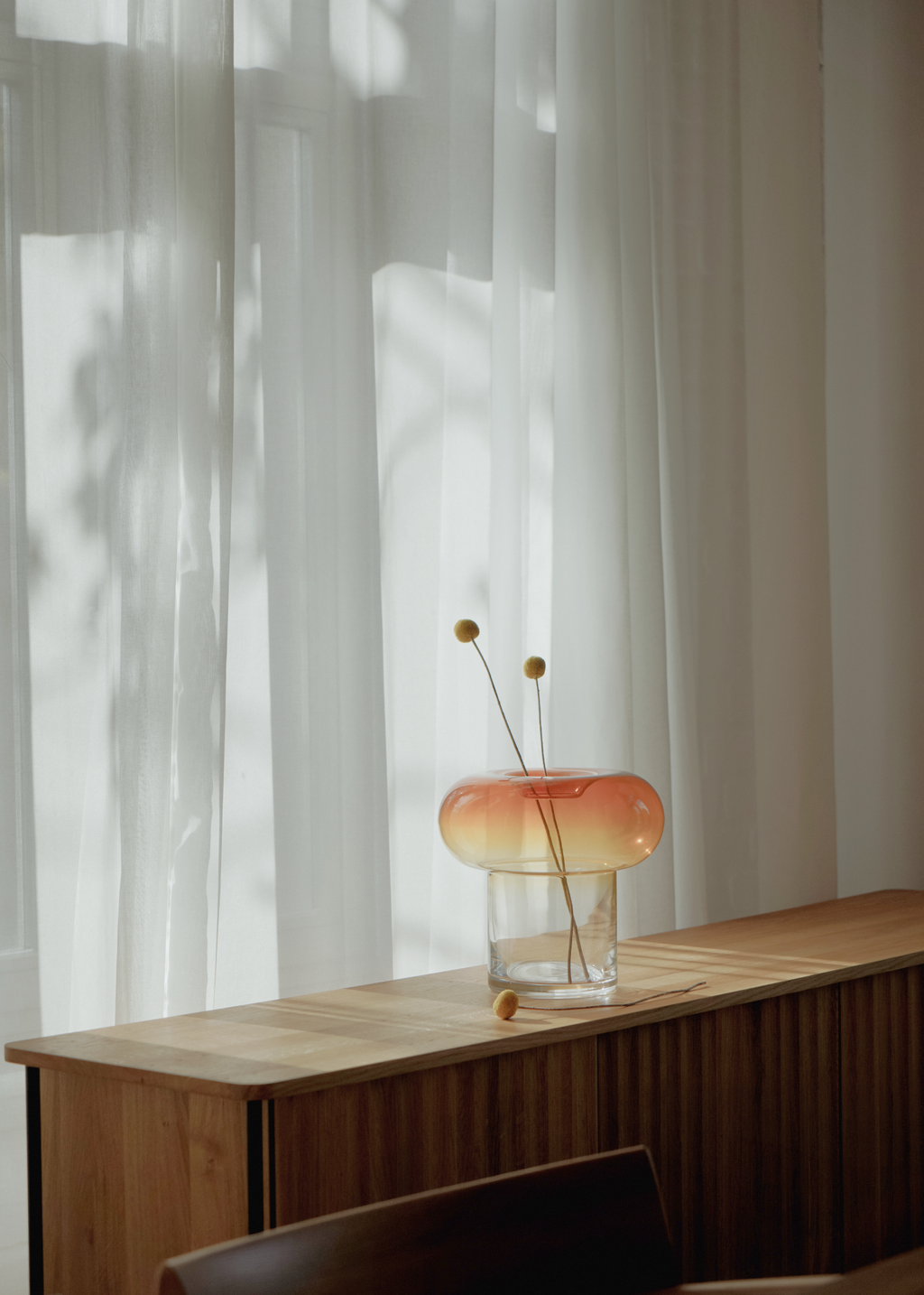 Glasvas med bärnstensfärgad rundad överdel och klar cylindrisk bas