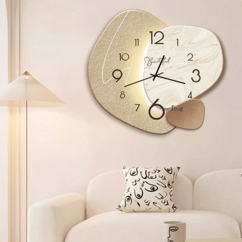 Beige organisk väggklocka med svarta siffror och dekorativa detaljer