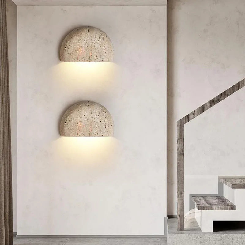 Halvrund beige vägglampa i travertin med texturerad yta