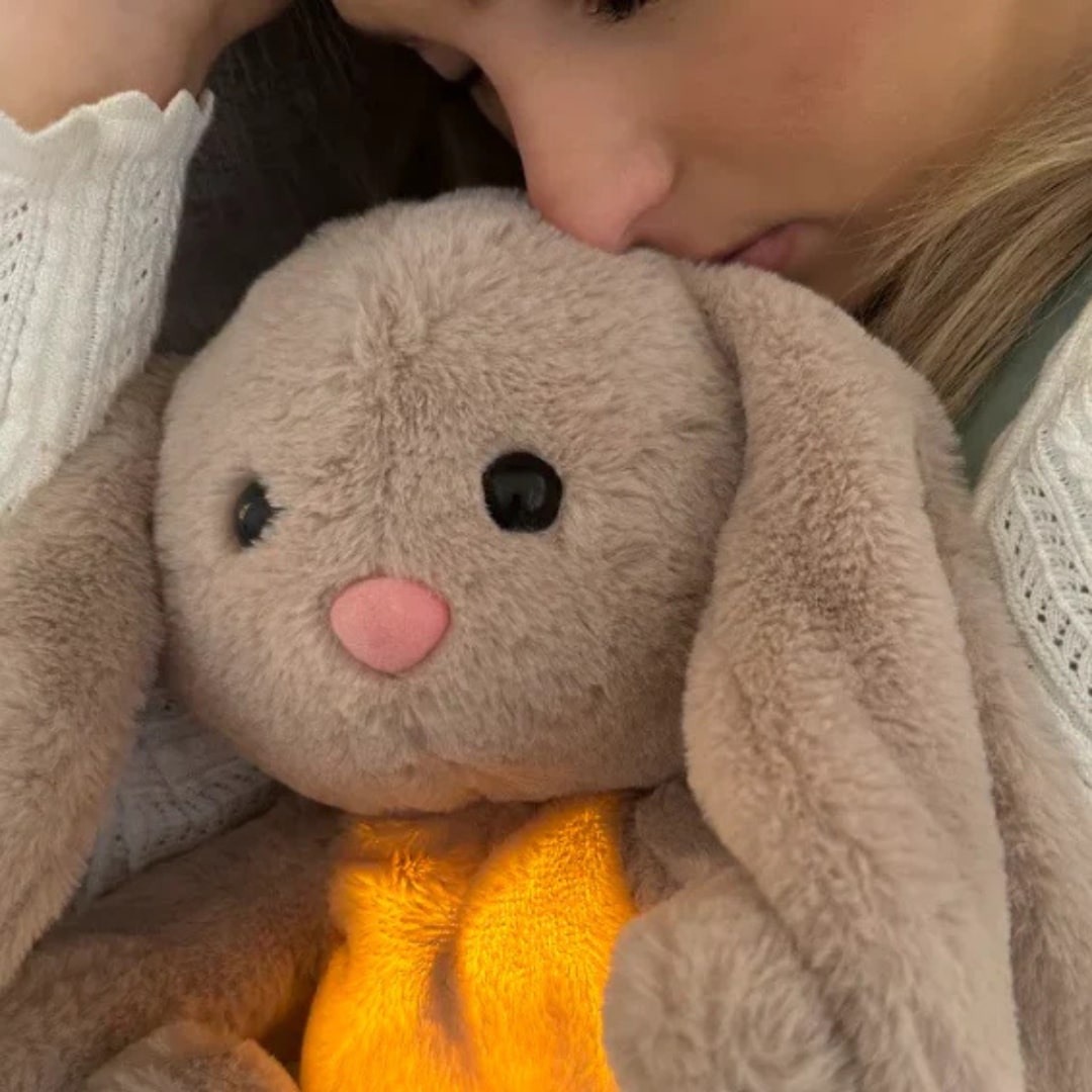 Grå mjuk gosedjurskanin med lysande orangegul mage