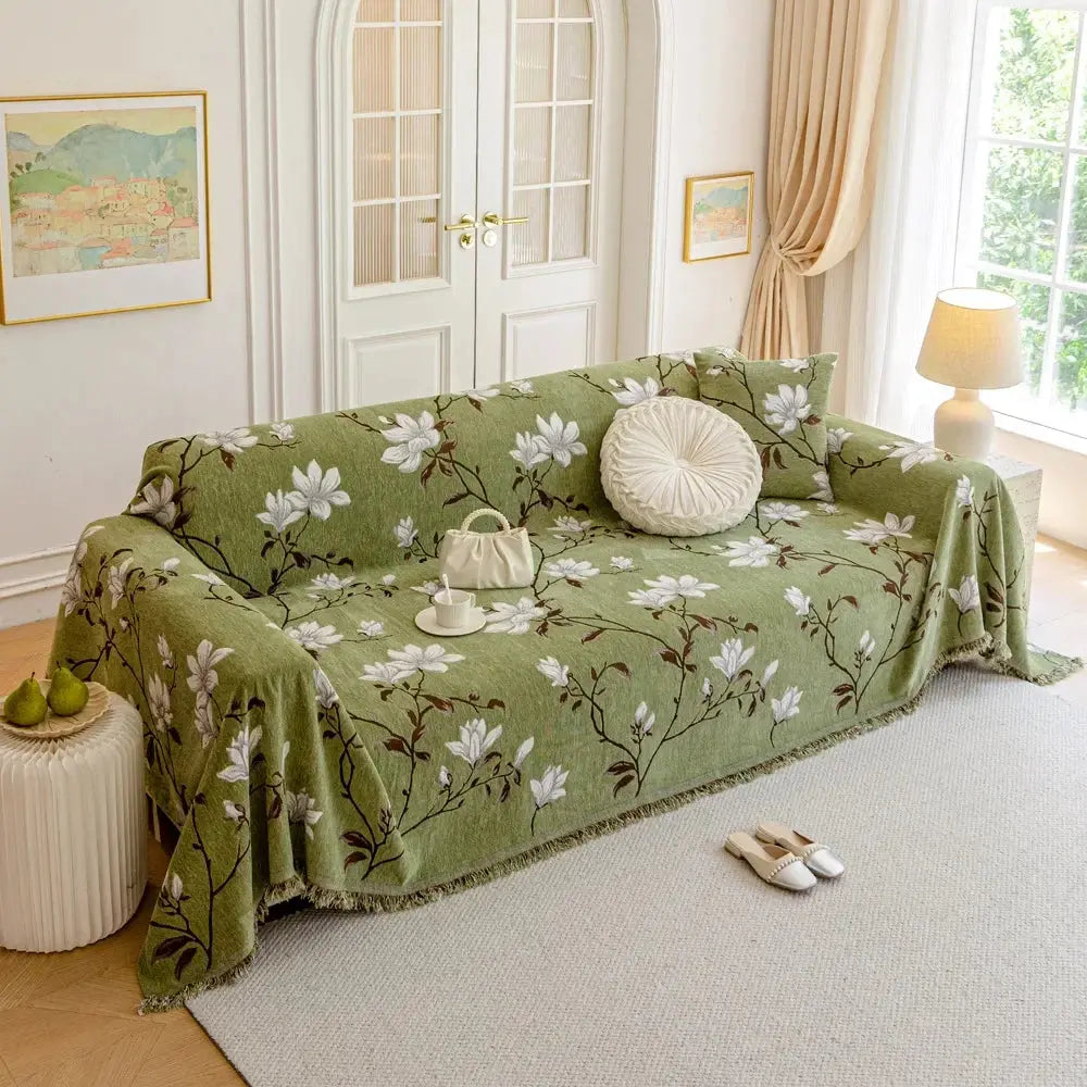 Sofföverdrag med blommönster och fransad kant på en soffa