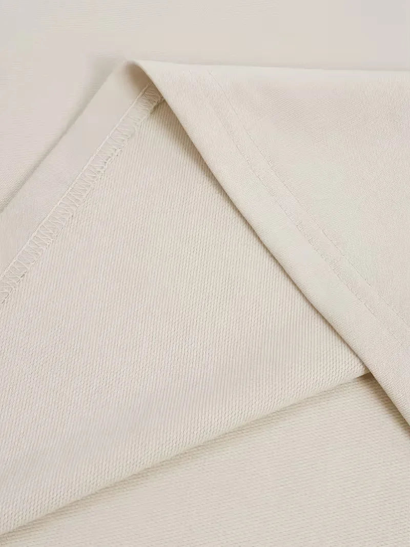 Beige oversized långärmad tröja med stor mörk textdesign på rygg och ärmar