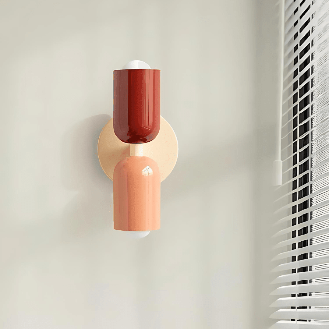 Vägglampa med två cylindriska delar och rund svart väggplatta