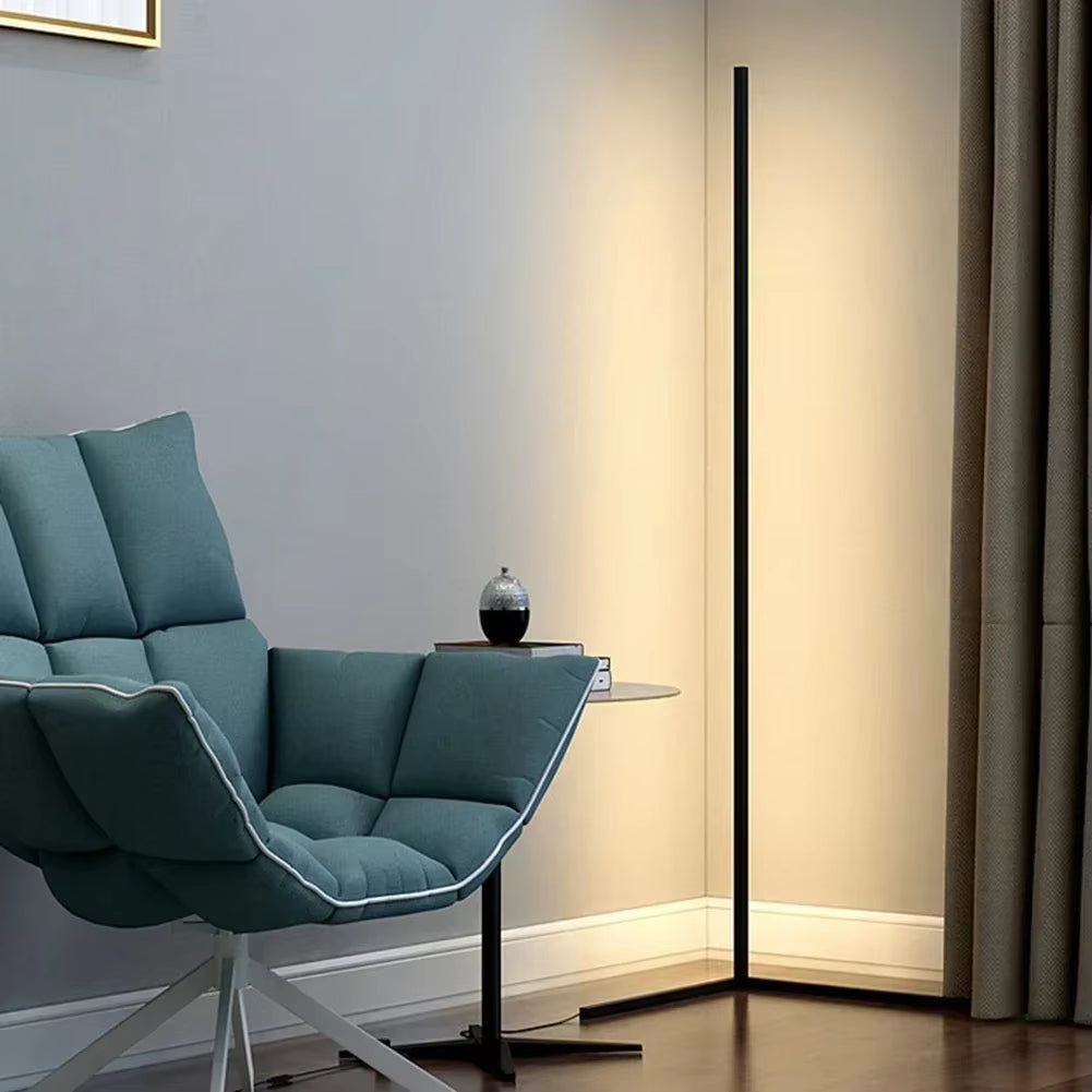 Smal dimbar LED-golvlampa placerad i ett hörn med varm belysning