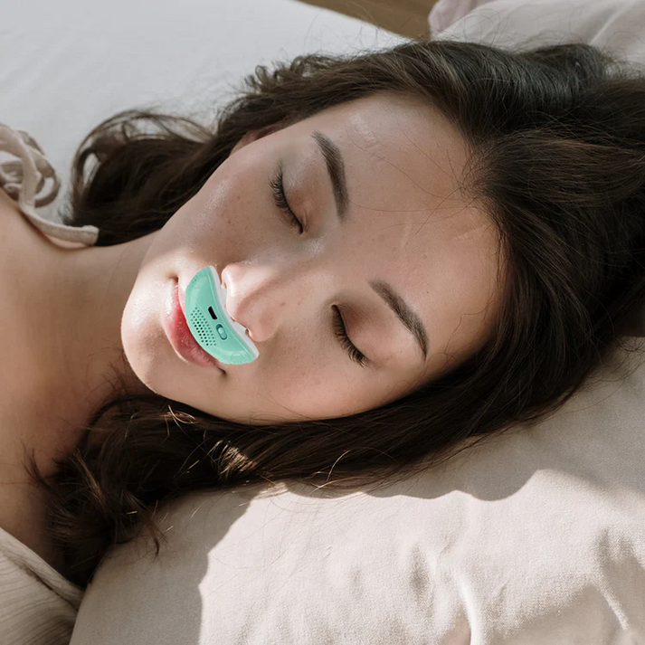 Kompakt CPAP-enhet med två vita näsdelar, ventilationsöppningar, strömbrytare och USB-port
